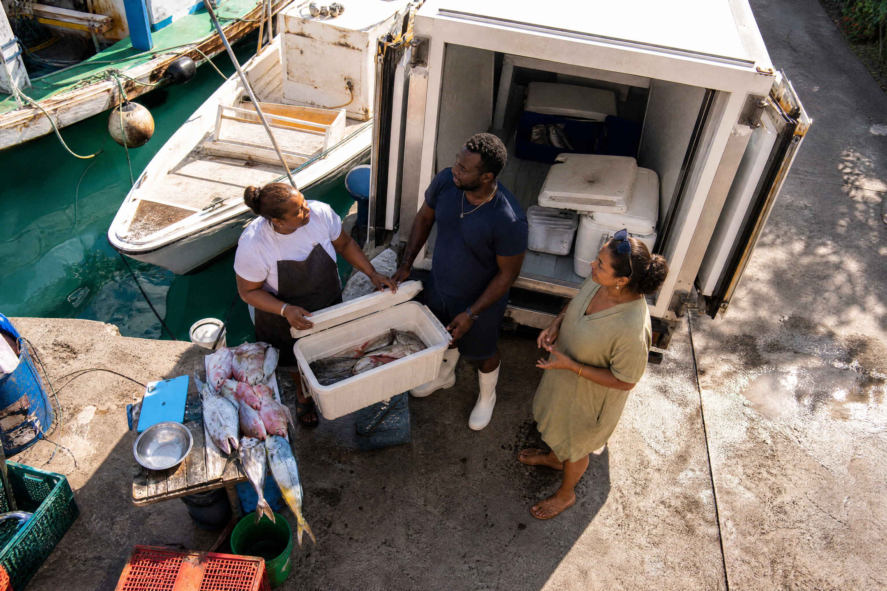 Poissonnière, livreur et restauratrice organisent une livraison de poisson frais en Guadeloupe.
